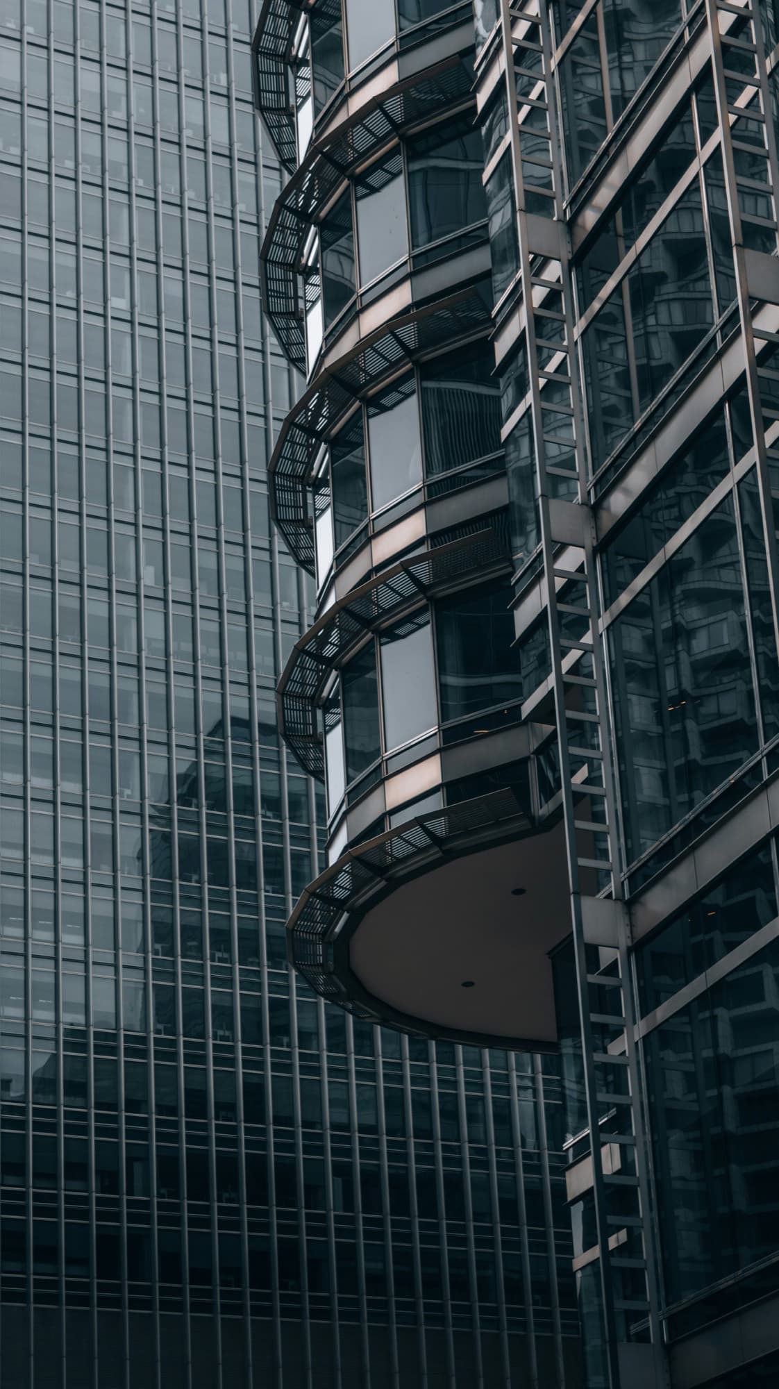 Dark glass-and-steel curtain wall detail with stacked balconies
