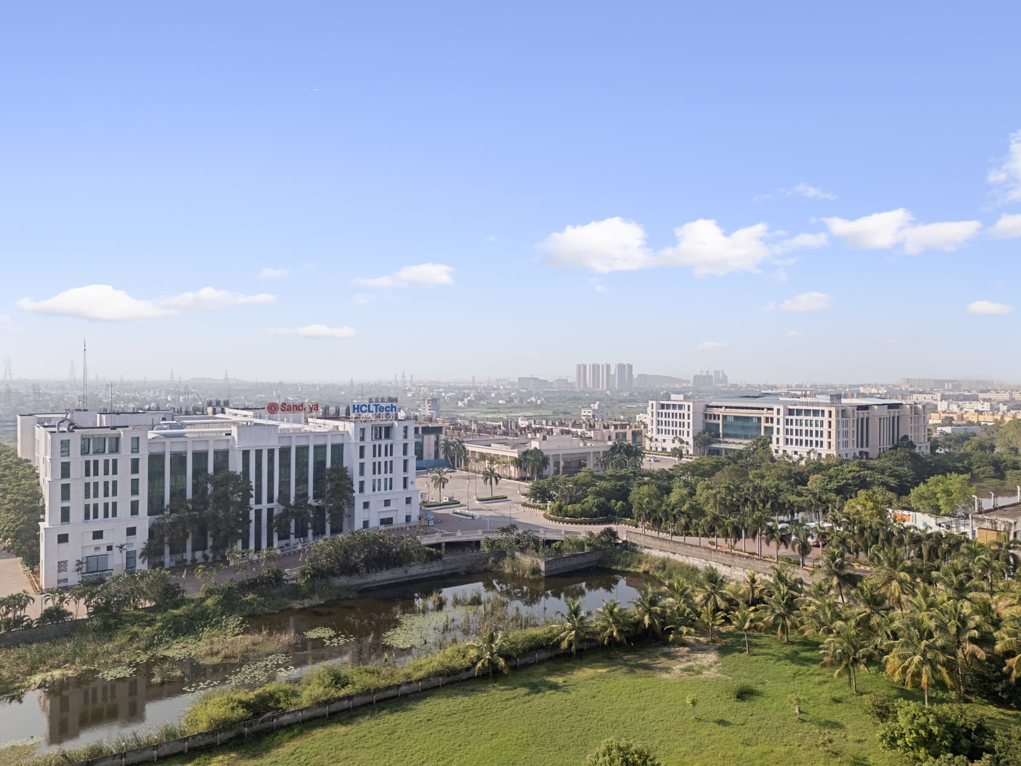 Sandhya Infocity blocks against the Navalur skyline and the campus water body