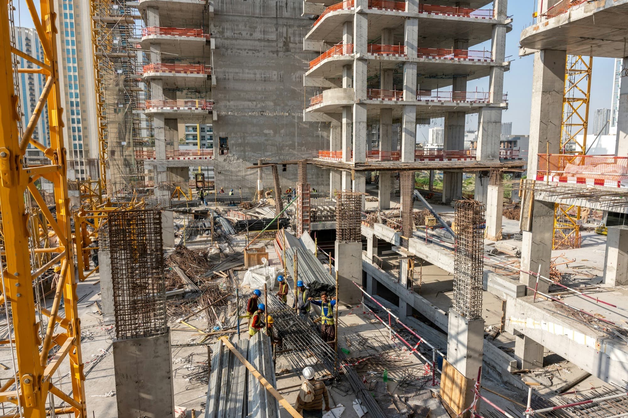Reinforced-concrete skeleton of a high-rise under construction with cranes and crews